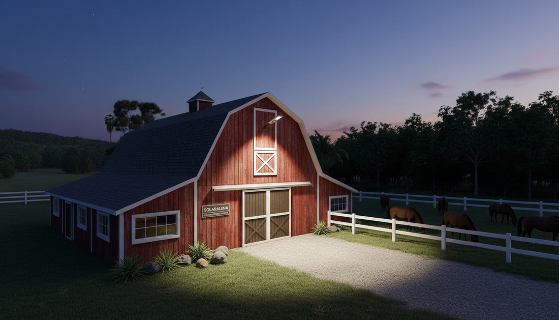 A high-output Solaraluma solar street light mounted on a classic red gambrel barn at dusk, casting a bright white light over the driveway. Horses graze peacefully behind a white fence in the pasture.